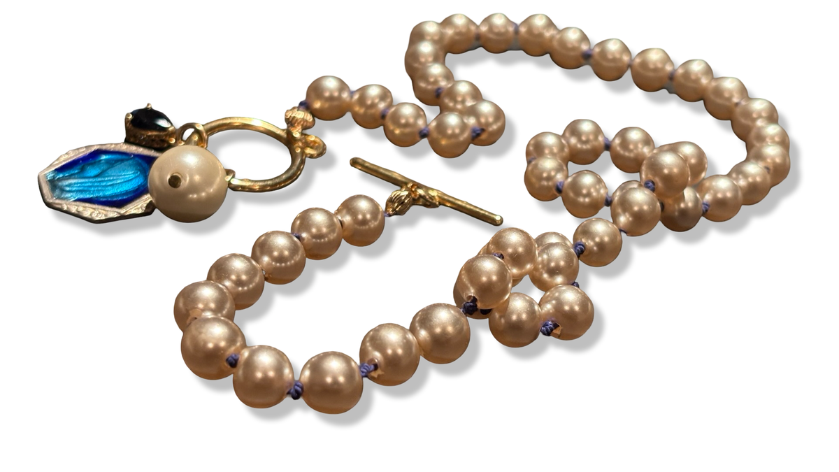 Collier de perles fantaisie, médaille émaillée, et goutte de strass bleue